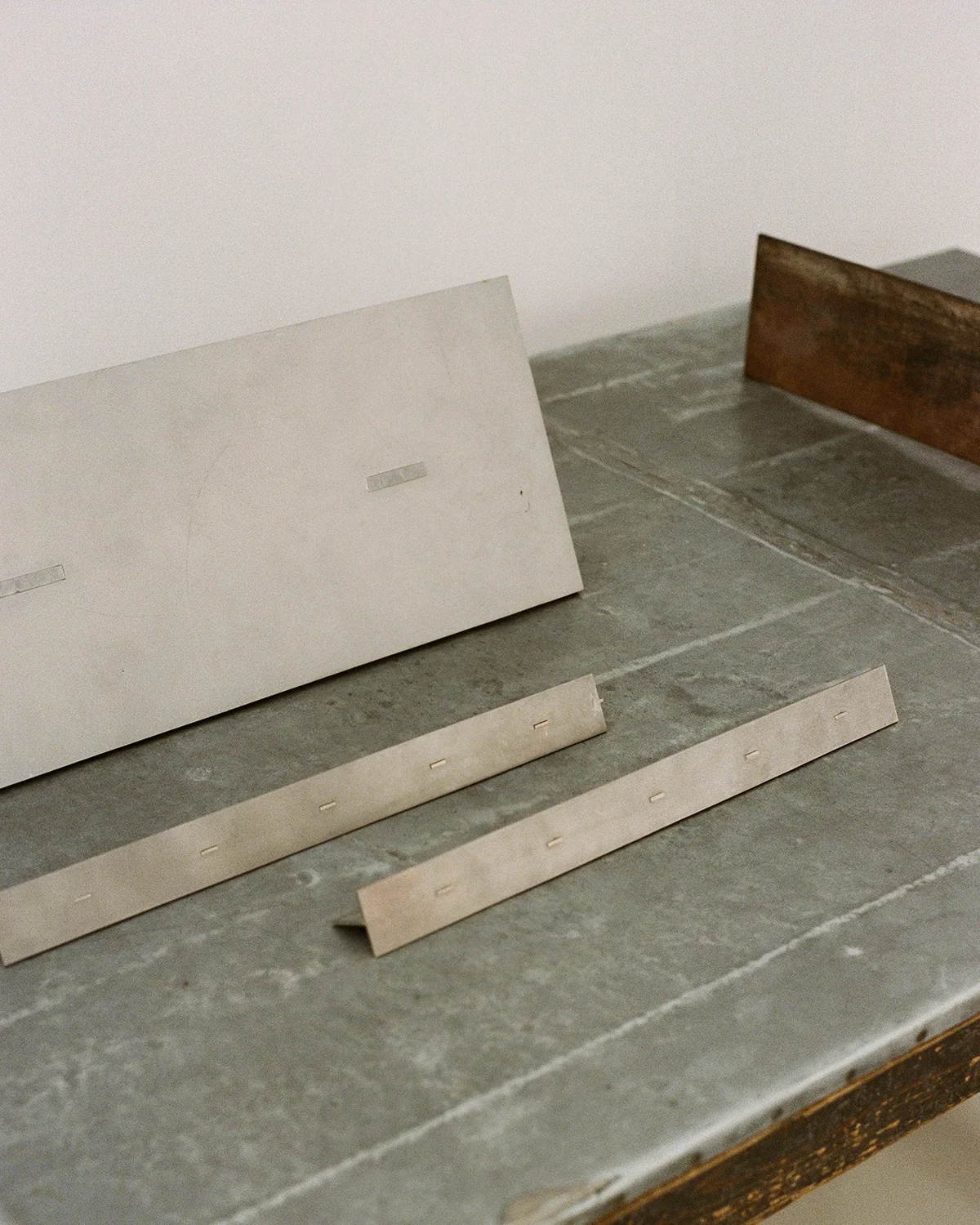 Folded steel shelves on a zinc-topped table